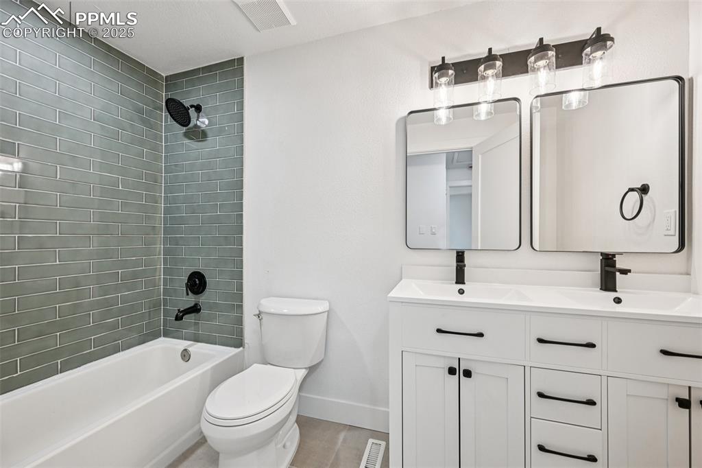 Image 16 of 49: Full bath with double vanity, bathtub / shower combination, and wood finish