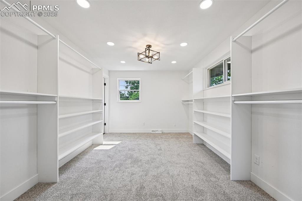 Image 24 of 49: Walk in closet featuring light carpet