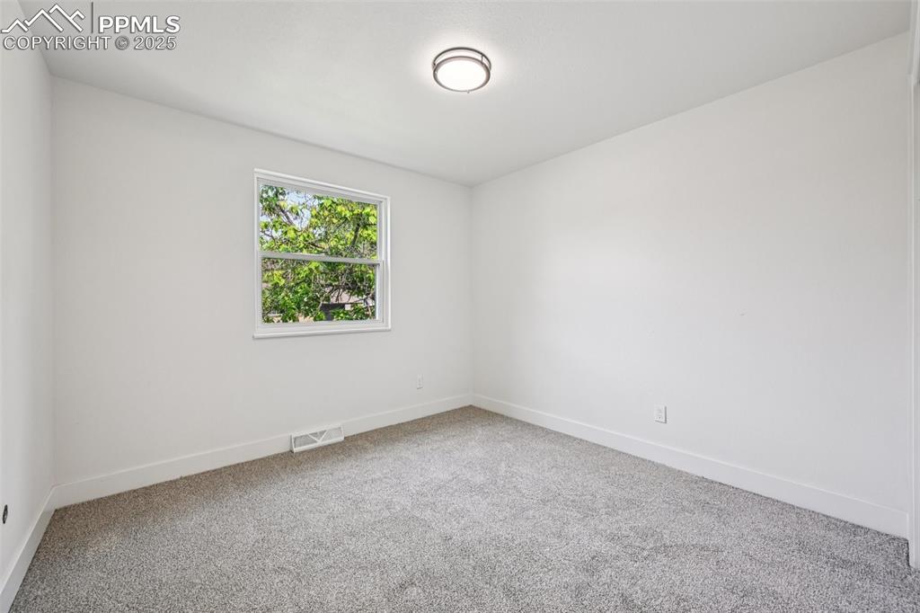 Image 26 of 49: Carpeted spare room with baseboards