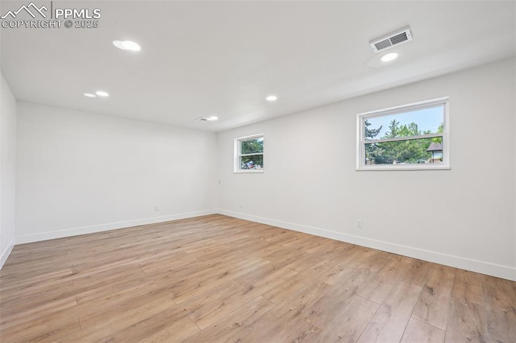 Image 28 of 49: Unfurnished room with light wood finished floors and recessed lighting