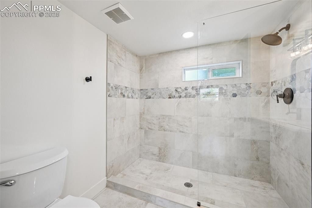 Image 32 of 49: Bathroom featuring a tile shower and recessed lighting