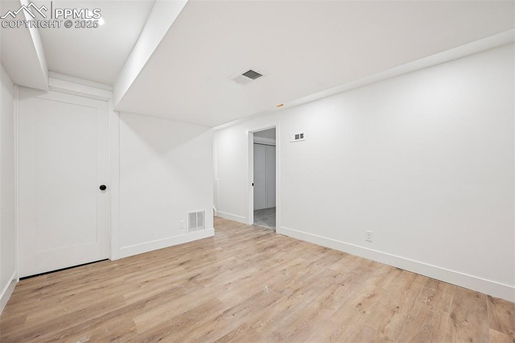Image 39 of 49: Empty room with light wood-style floors and recessed lighting