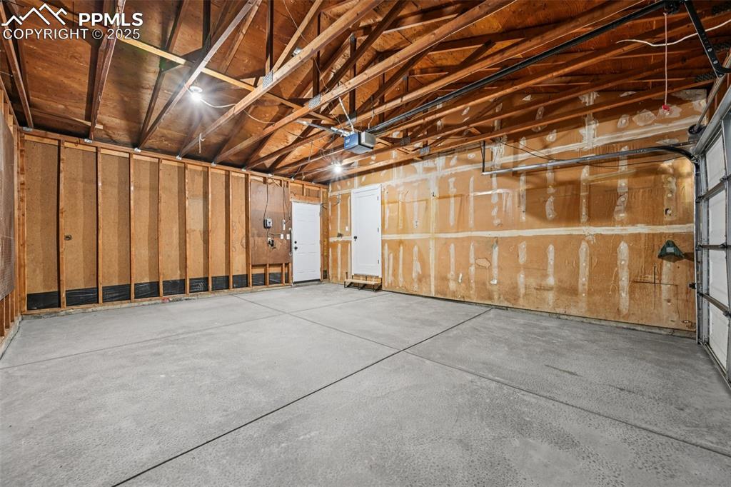 Image 45 of 49: Garage featuring a garage door opener