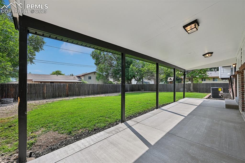 Image 46 of 49: Fenced backyard with a patio