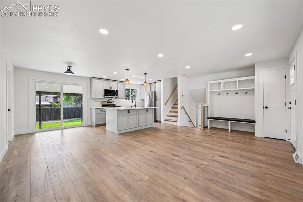 Image 5 of 49: Kitchen featuring light countertops, light wood-type flooring, recessed lig
