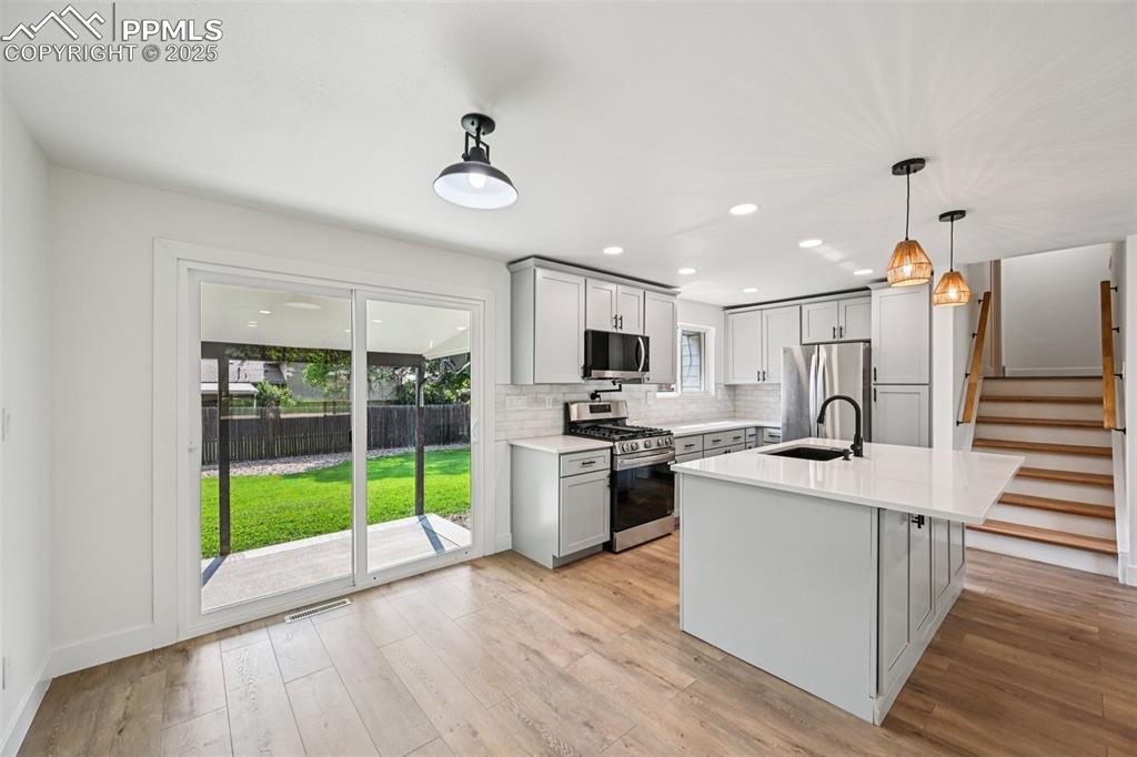 Image 7 of 49: Kitchen with gray cabinets, appliances with stainless steel finishes, light