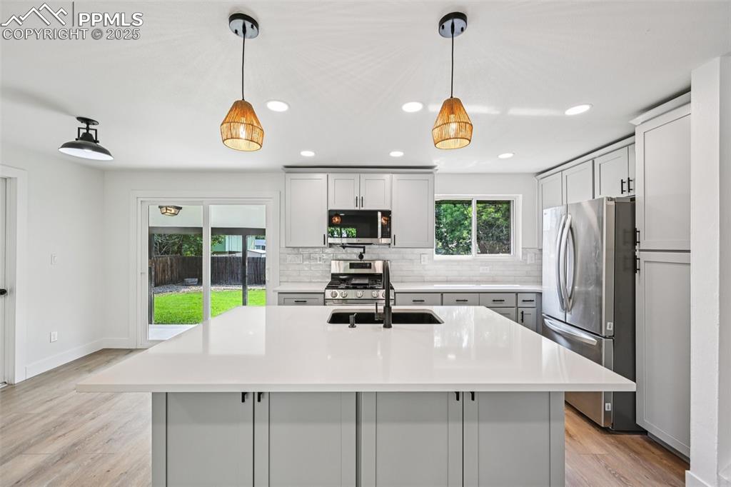 Image 9 of 49: Kitchen with recessed lighting, stainless steel appliances, light counterto