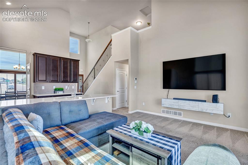 Image 14 of 38: Open-concept living space featuring high ceilings and neutral wall tones