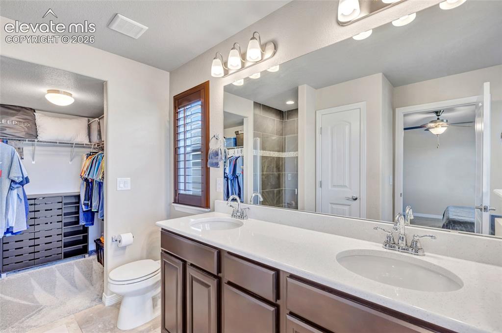 Image 20 of 38: Dual vanity with undermount sinks, white countertops, and dark wood-finish