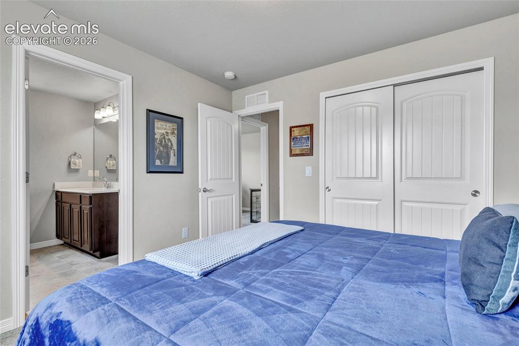 Image 24 of 38: Bedroom featuring light gray walls, white trim, and white bi-fold closet do