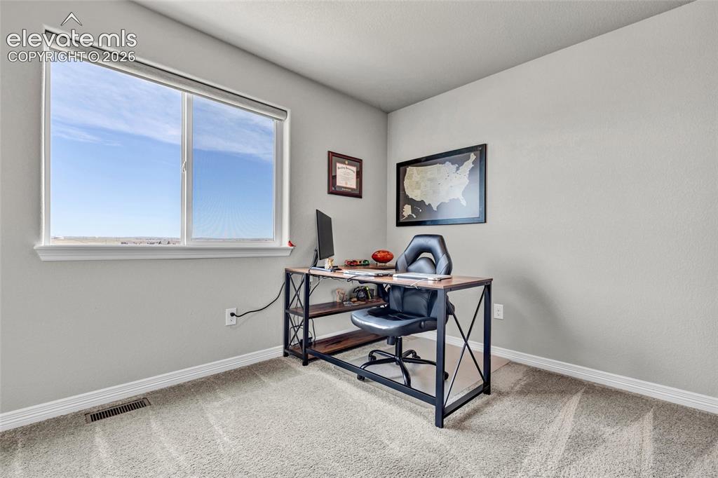 Image 29 of 38: Light-filled room featuring a large window, neutral wall paint, white trim,