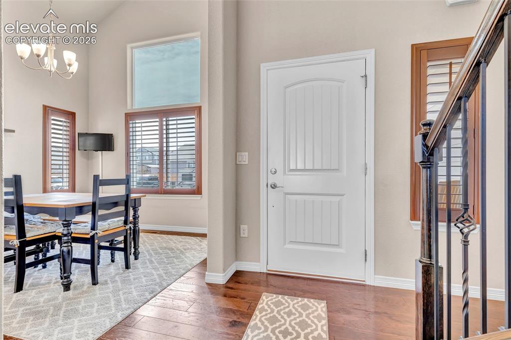 Image 3 of 38: Entryway featuring rich wood-finish flooring, a white paneled door, and an