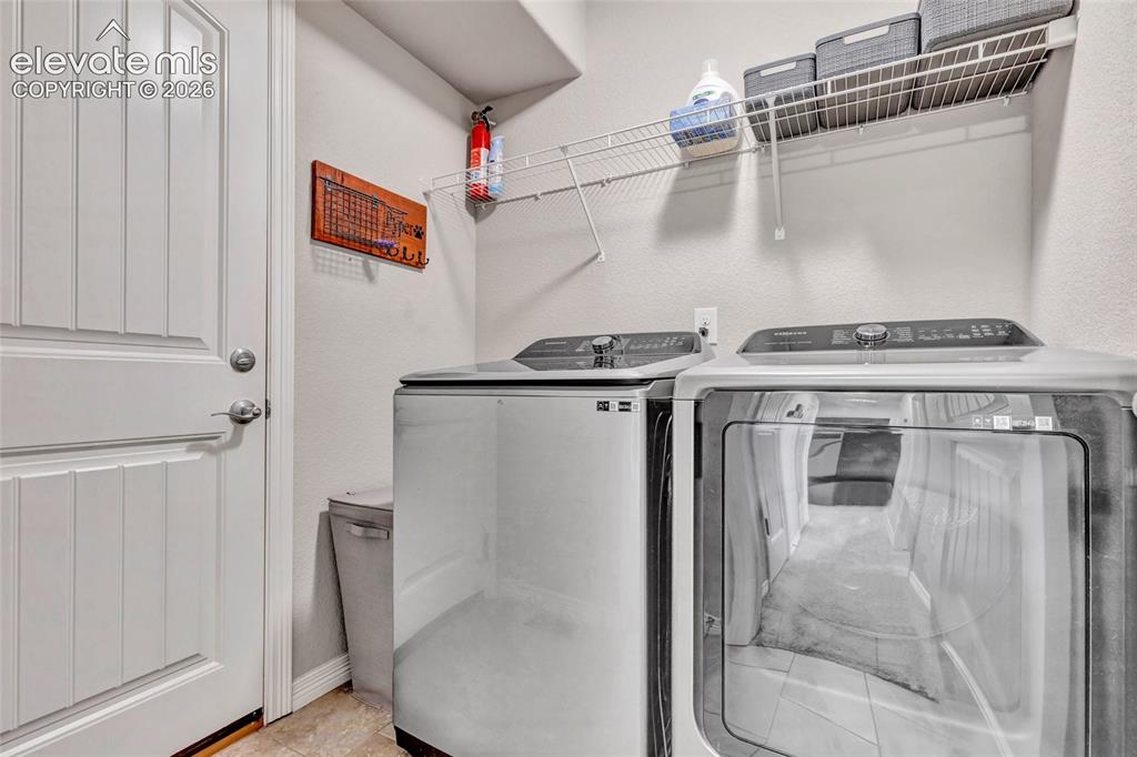 Image 31 of 38: Dedicated utility space featuring a paneled interior door, light-toned wall