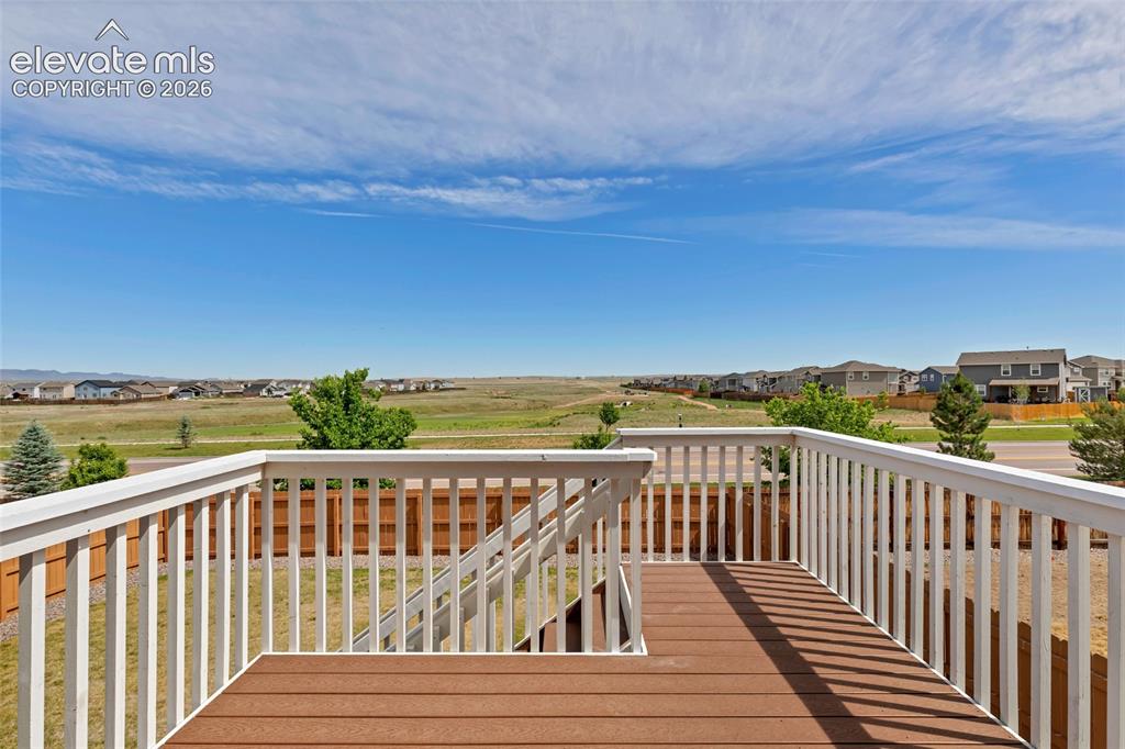 Image 34 of 38: Expansive outdoor deck featuring wood-finish flooring, white railing, and o