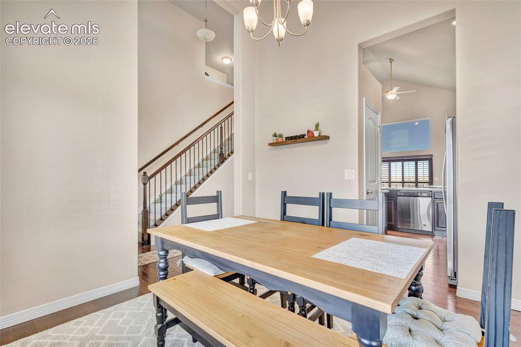 Image 4 of 38: Dining area featuring a contemporary chandelier, wood-finish flooring