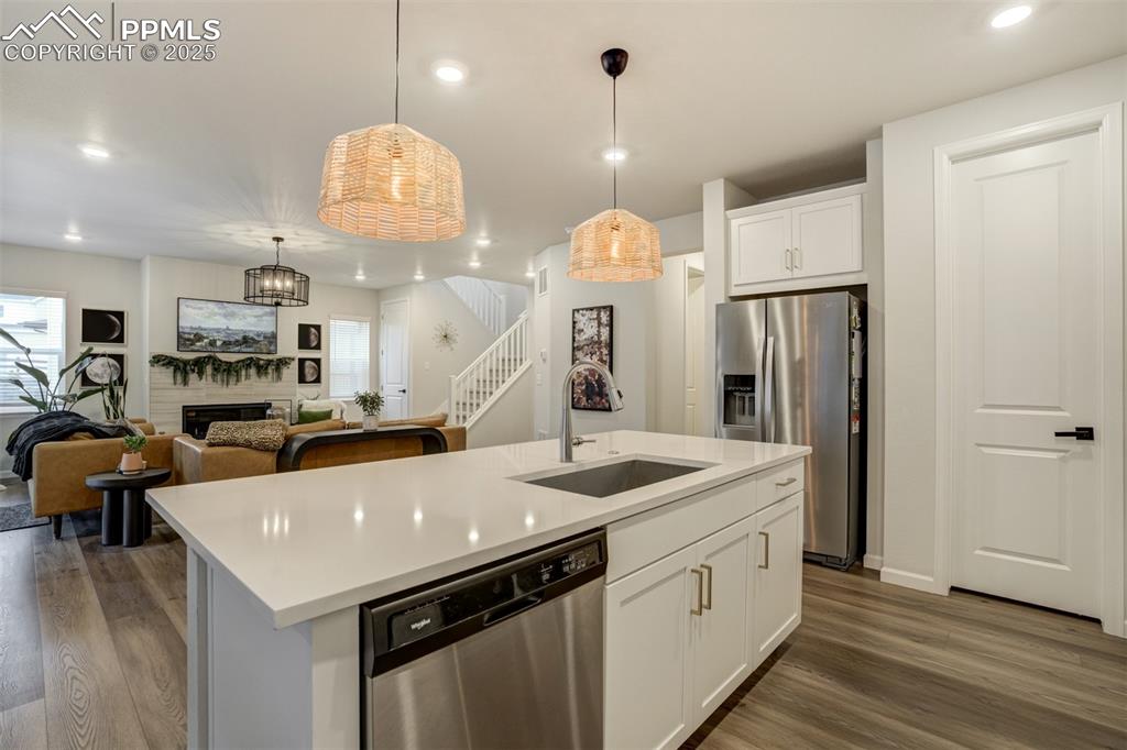 Image 10 of 50: Kitchen featuring open floor plan, stainless steel appliances, white cabine