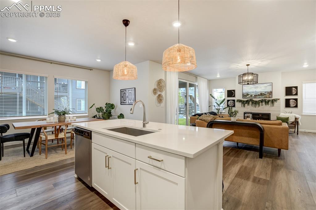 Image 12 of 50: Kitchen featuring white cabinetry, open floor plan, wood finished floors, a