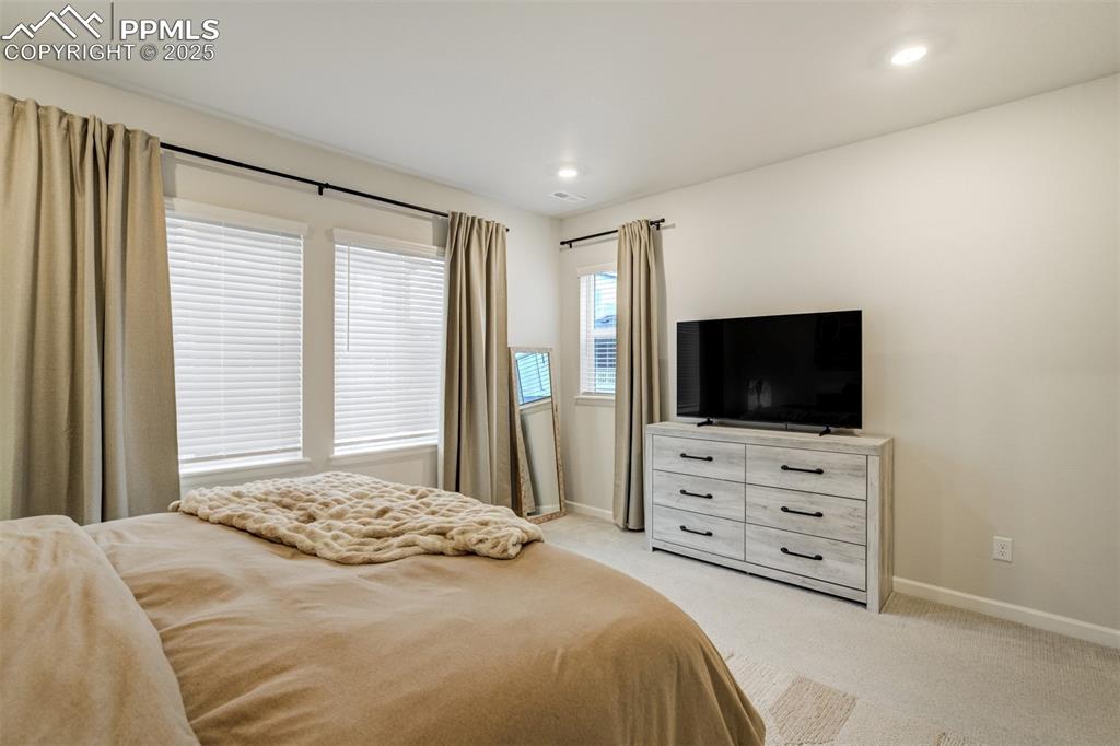 Image 21 of 50: Bedroom with light carpet and recessed lighting