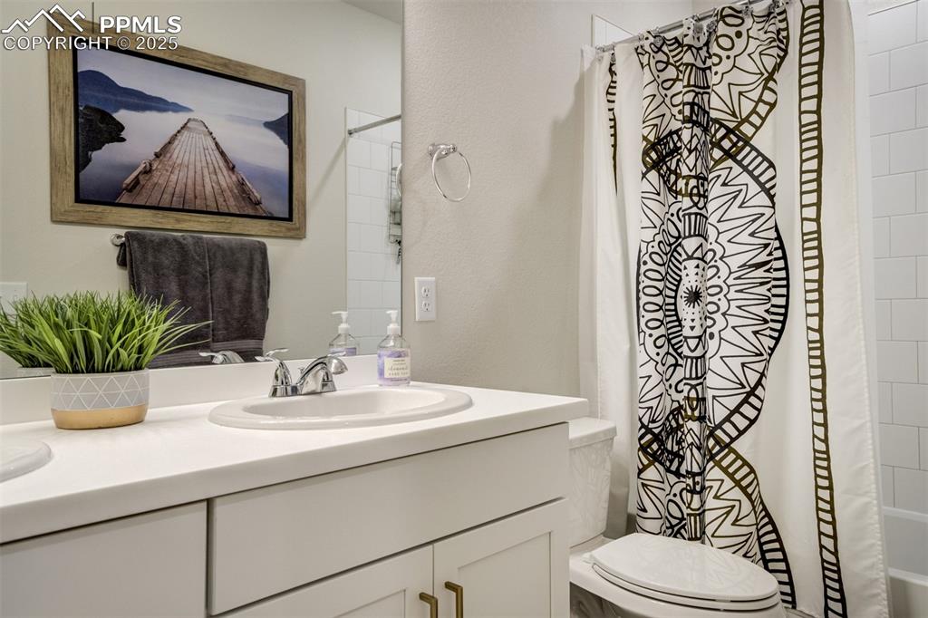 Image 30 of 50: Full bathroom with a double vanity, shower / tub combo
