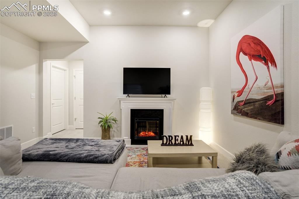 Image 35 of 50: Living area with a glass covered fireplace and recessed lighting