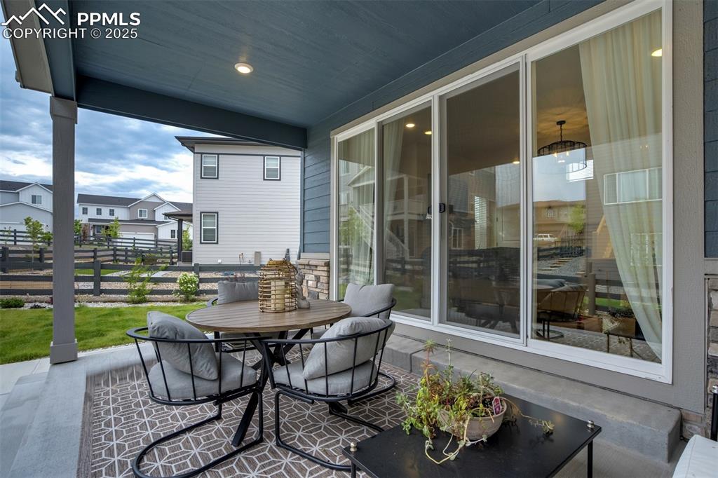 Image 41 of 50: Fenced backyard with a covered patio, raised garden beds, and outdoor dinin