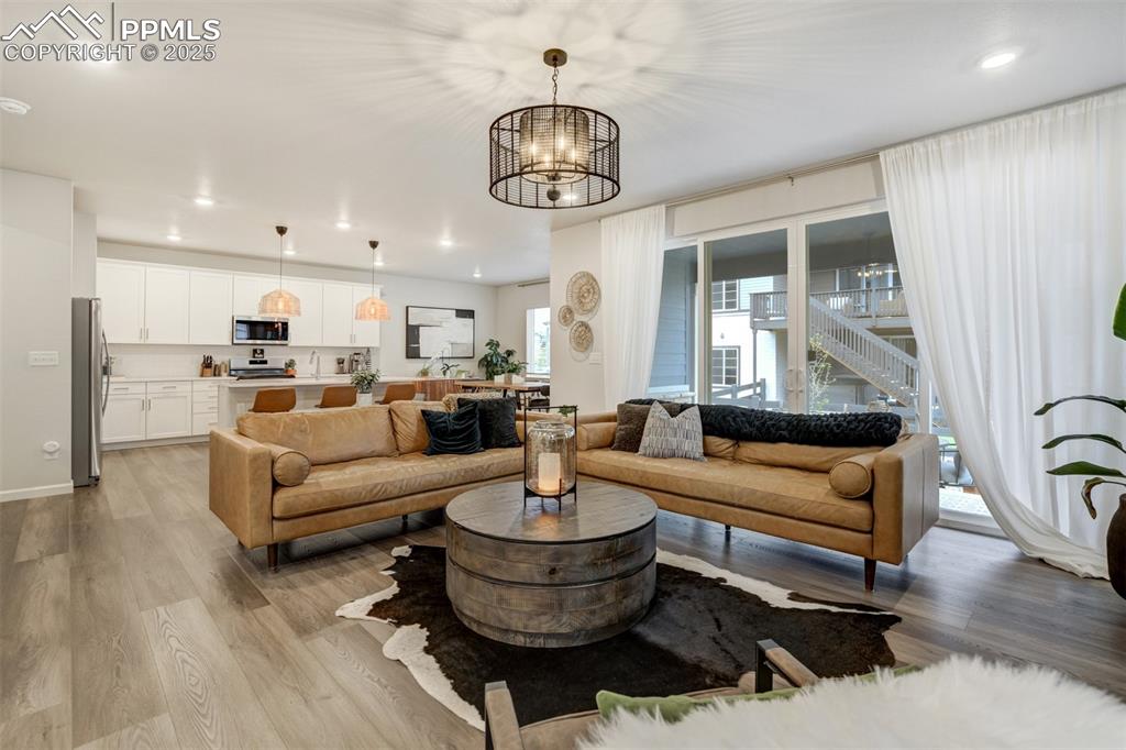 Image 5 of 50: Living room with recessed lighting, light wood-style floors, and a chandeli