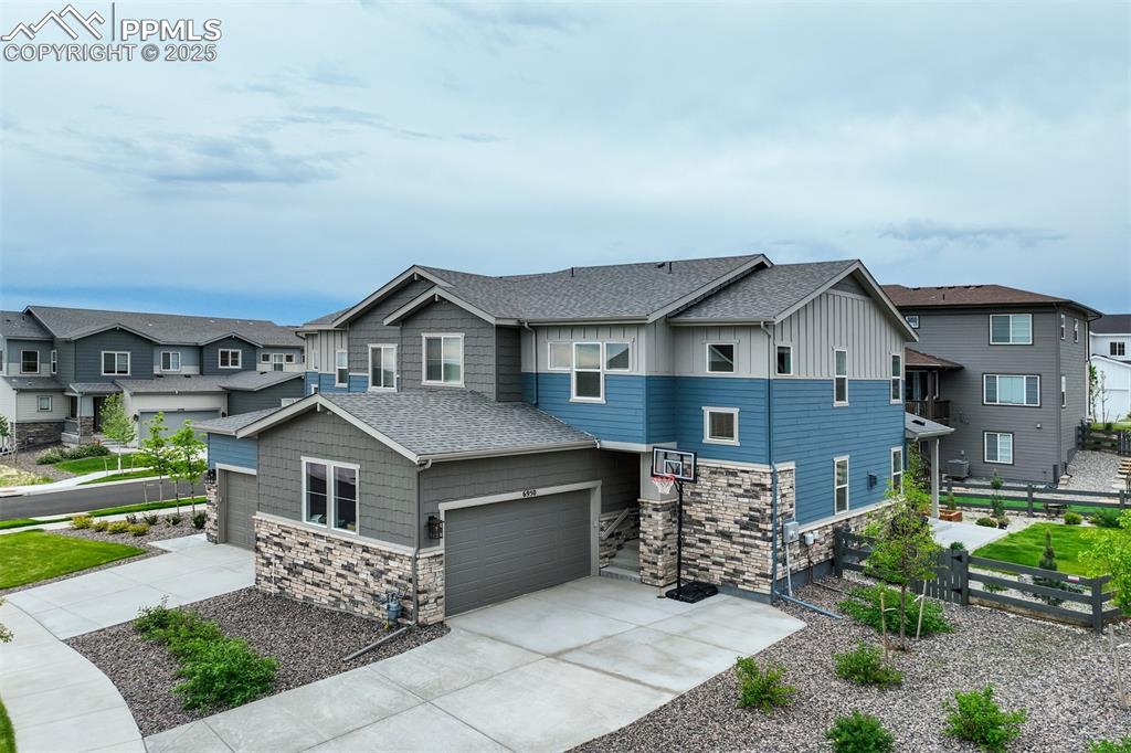 Image 50 of 50: View of front of property featuring a shingled roof, stone siding, a reside