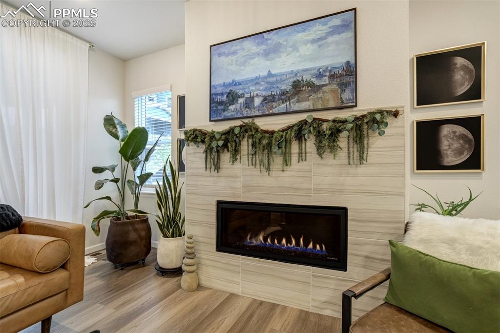 Image 6 of 50: Living room with wood finished floors and a tiled fireplace
