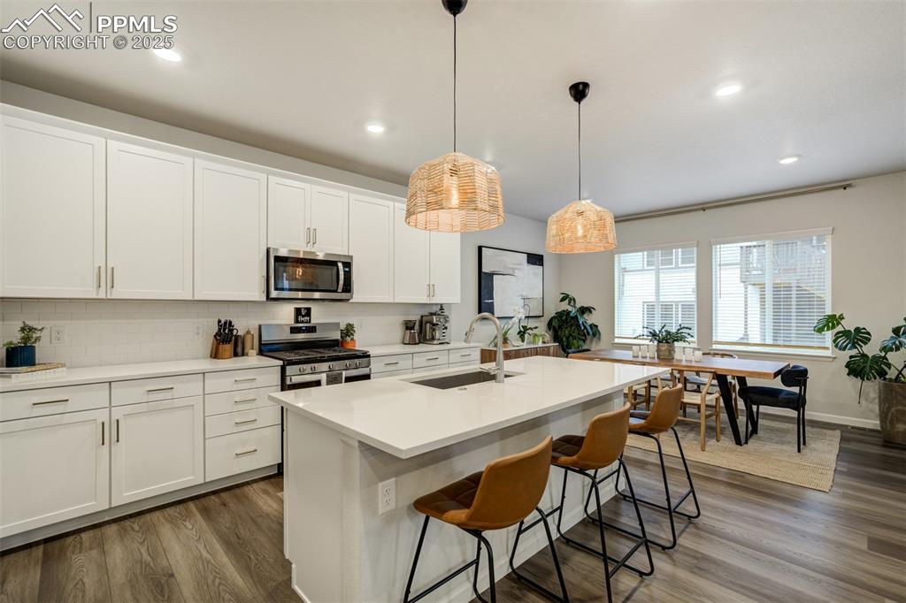 Image 9 of 50: Kitchen featuring tasteful backsplash, wood-type flooring, stainless steel 