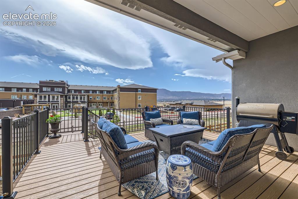 Image 36 of 38: Extended composite covered deck with mountain views in the distance.