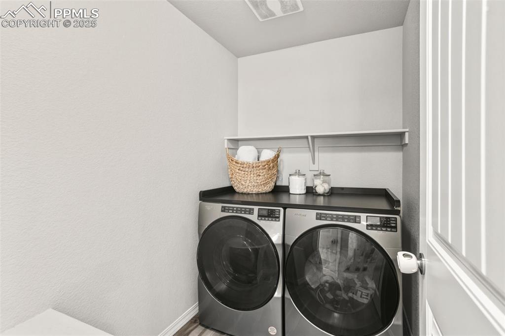 Image 15 of 37: Washroom with washing machine and clothes dryer and a textured wall