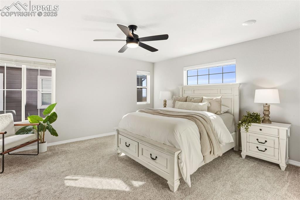 Image 16 of 37: Bedroom with light carpet and a ceiling fan