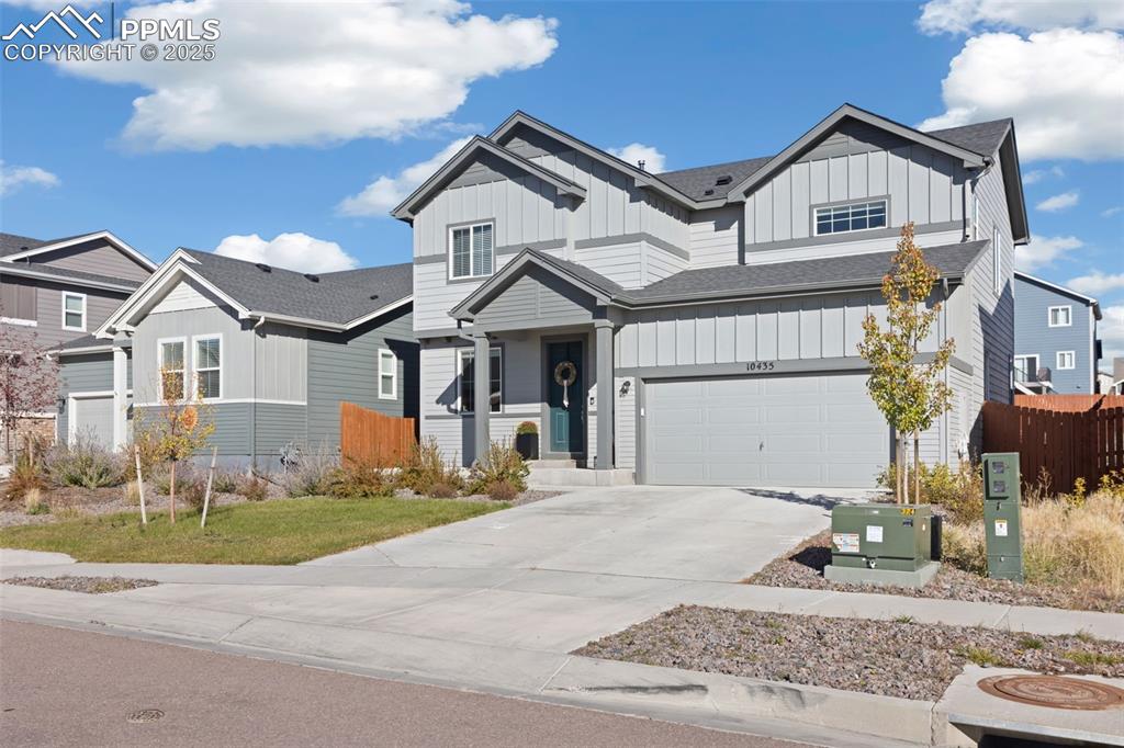 Image 2 of 37: View of front of property with board and batten siding, driveway, roof with