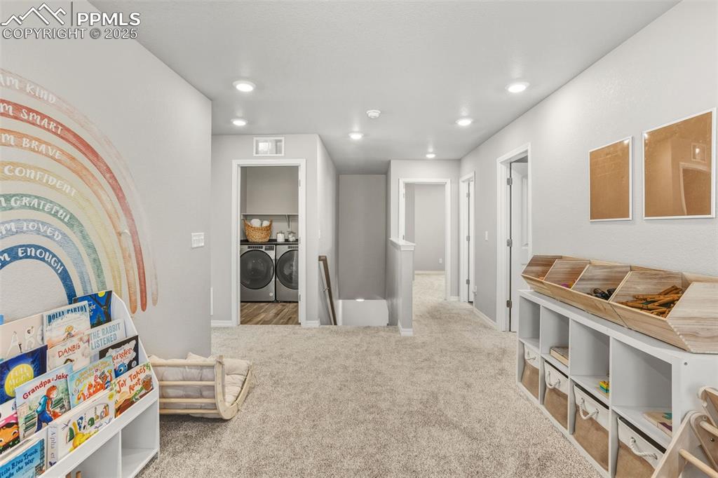 Image 21 of 37: Recreation room featuring separate washer and dryer, light colored carpet,