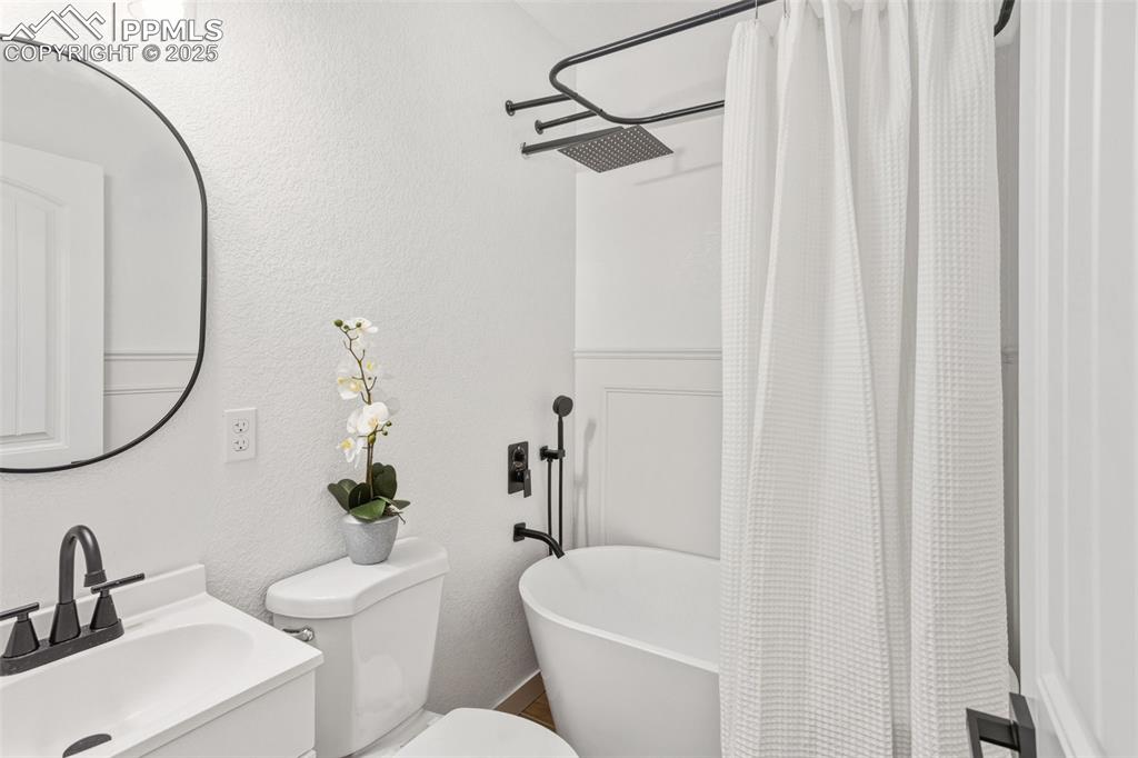Image 27 of 37: Bathroom with a textured wall and vanity
