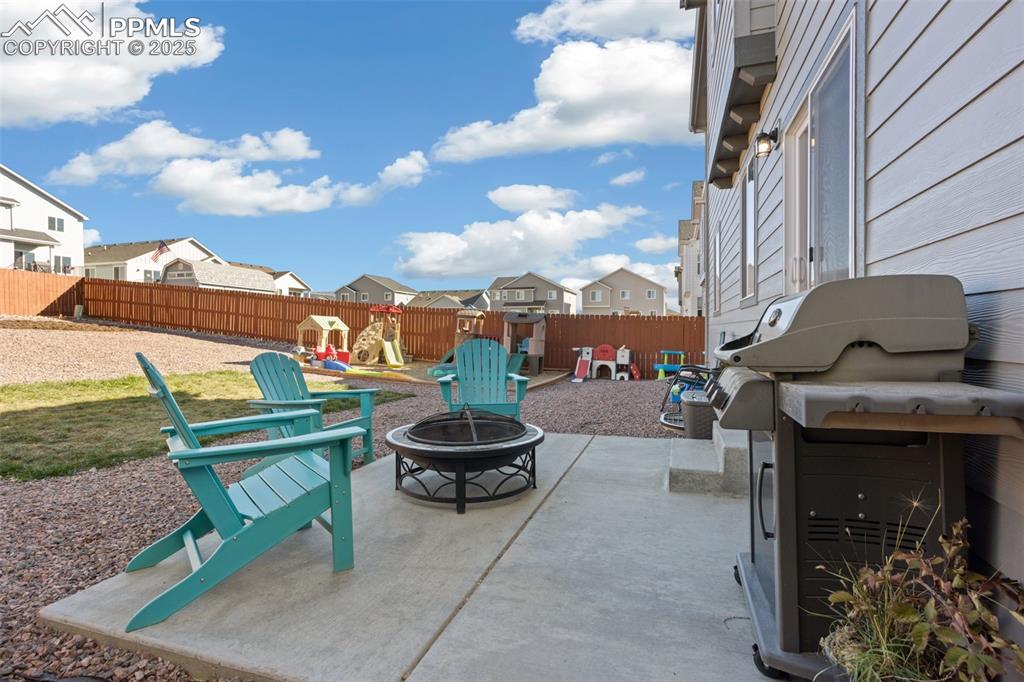Image 33 of 37: Fenced backyard with a patio, a playground, grilling area, a residential vi