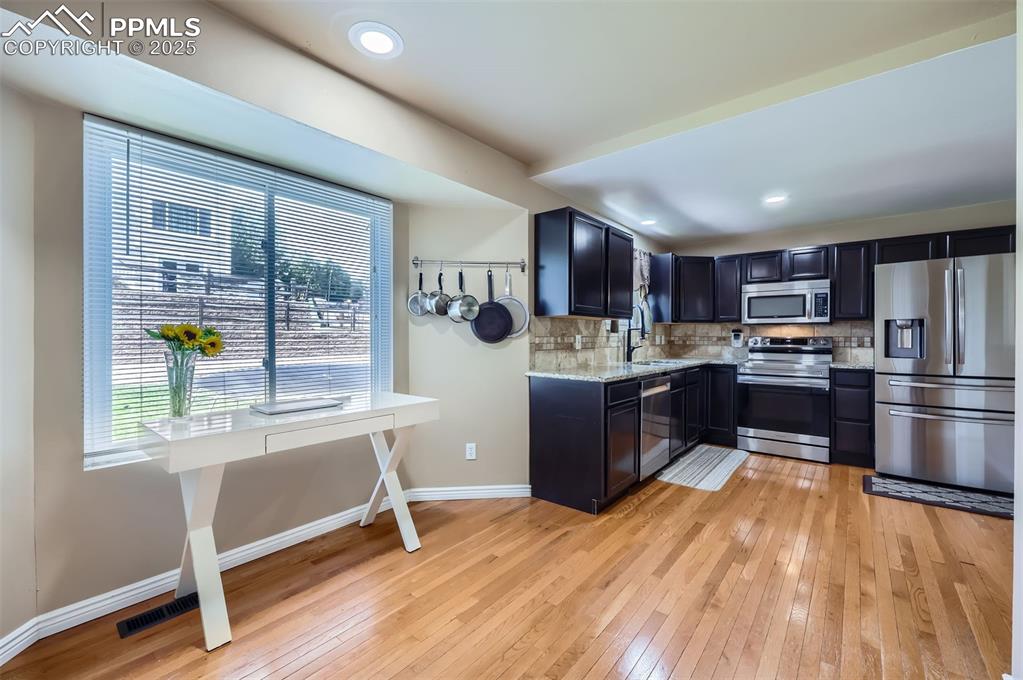 Image 10 of 28: Kitchen featuring stainless steel appliances, light granite countertops, he