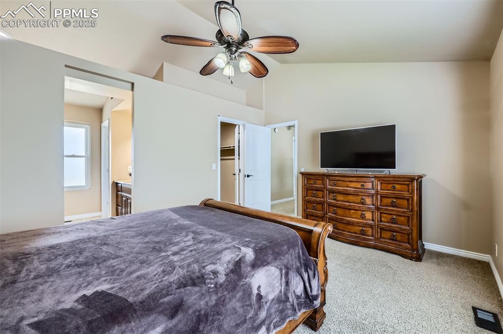 Image 14 of 28: Bedroom featuring lofted ceiling, carpet flooring, ceiling fan, and ensuite