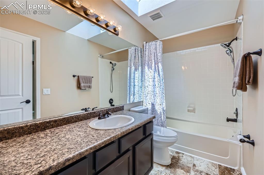 Image 20 of 28: Full Jack and Jill bath featuring vanity, shower / bathtub combination with