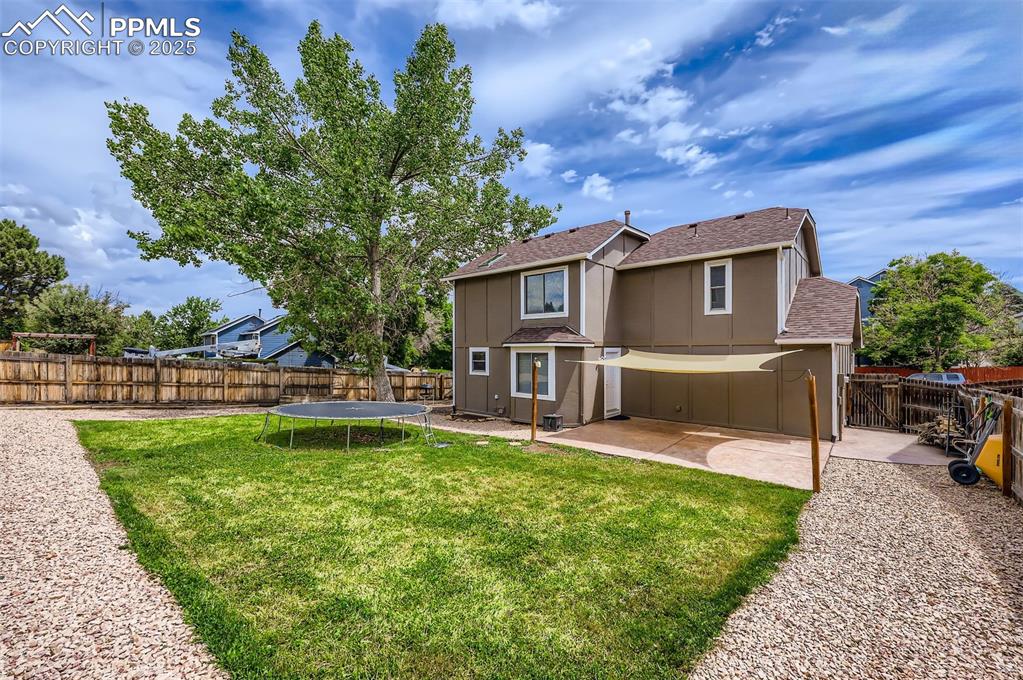 Image 28 of 28: Back of property featuring a stamped concrete patio, a fenced backyard, and