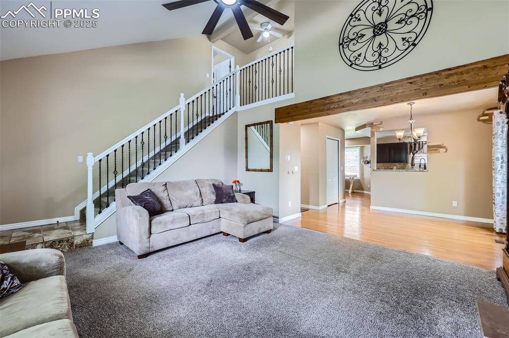 Image 5 of 28: Living room featuring carpet and wood flooring, a ceiling fan, beamed ceili