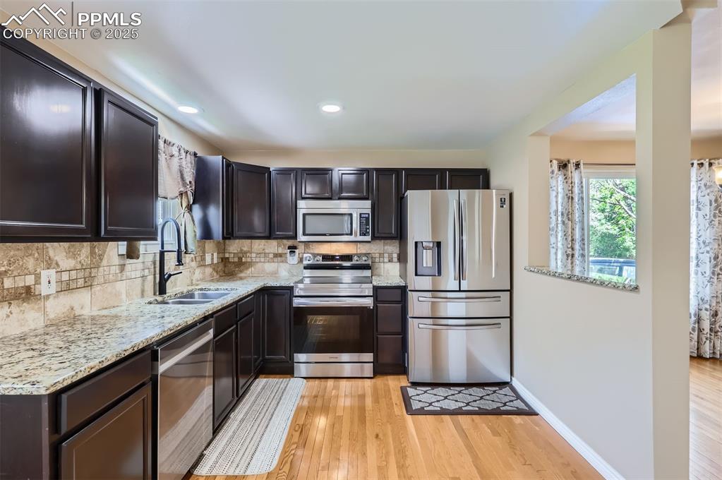 Image 9 of 28: Kitchen featuring appliances with stainless steel finishes, decorative back
