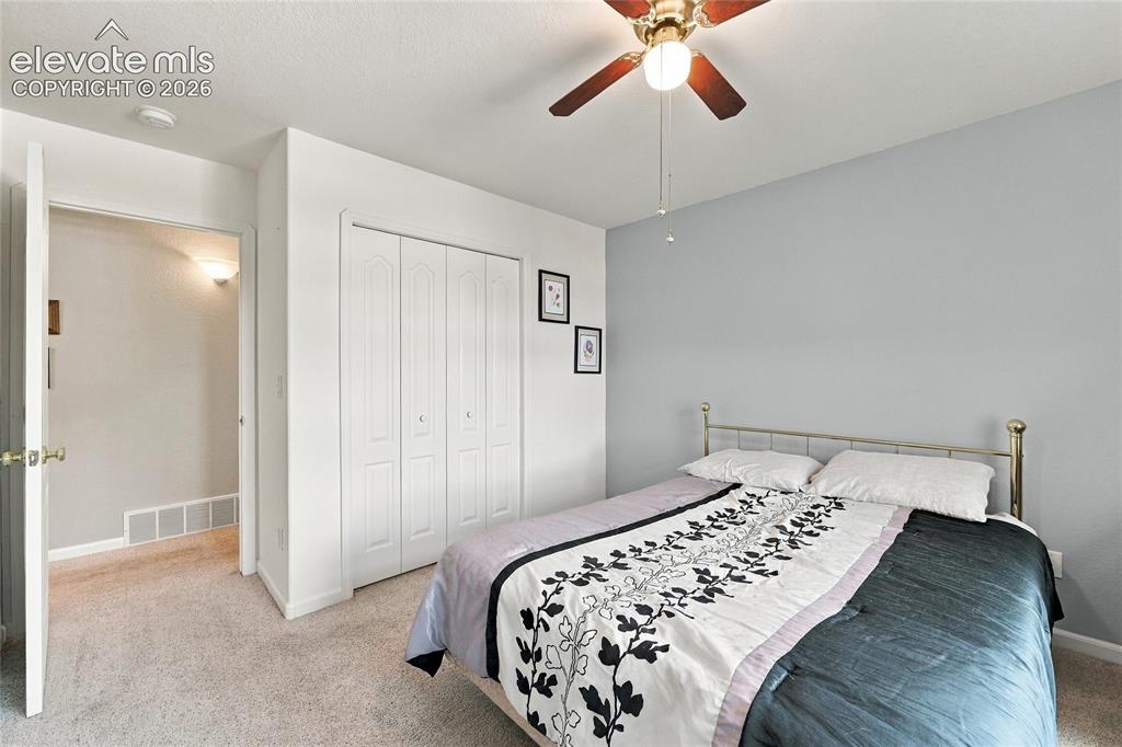 Image 18 of 36: Neutral wall paint and flooring, a ceiling fan with light fixture, and bi-f