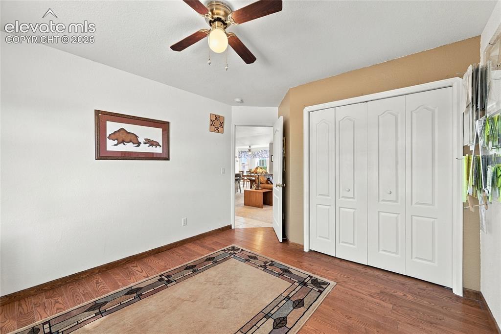 Image 21 of 36: Wood-finish flooring, white walls, and a ceiling fan with integrated lighti