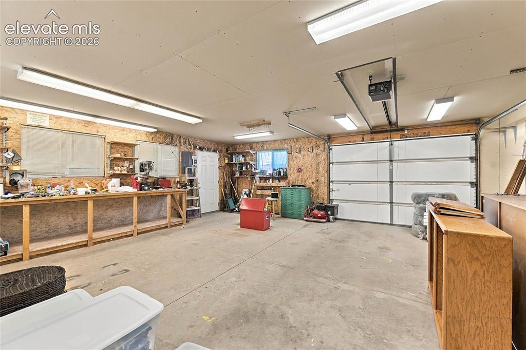 Image 31 of 36: Concrete flooring, built-in workbench, heating, wall a/c, and multiple wind