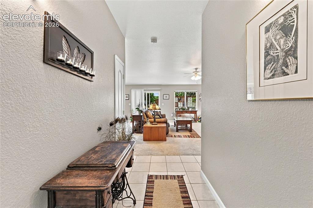 Image 4 of 36: Vaulted ceiling, recessed lighting, and tile flooring at the entry