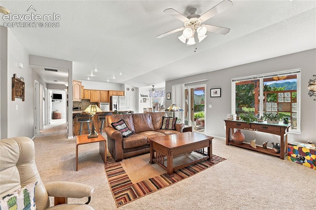 Image 6 of 36: Open-concept living space featuring a ceiling fan with integrated lighting,