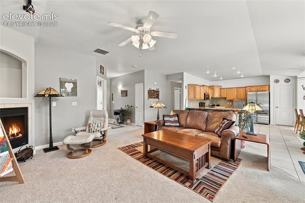 Image 7 of 36: Carpeted living area with a built-in fireplace, a ceiling fan, and recessed