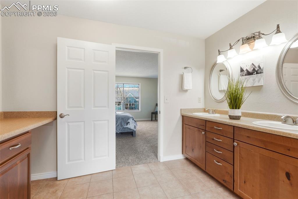 Image 22 of 44: The property features a vanity area with light-colored countertops, two sin