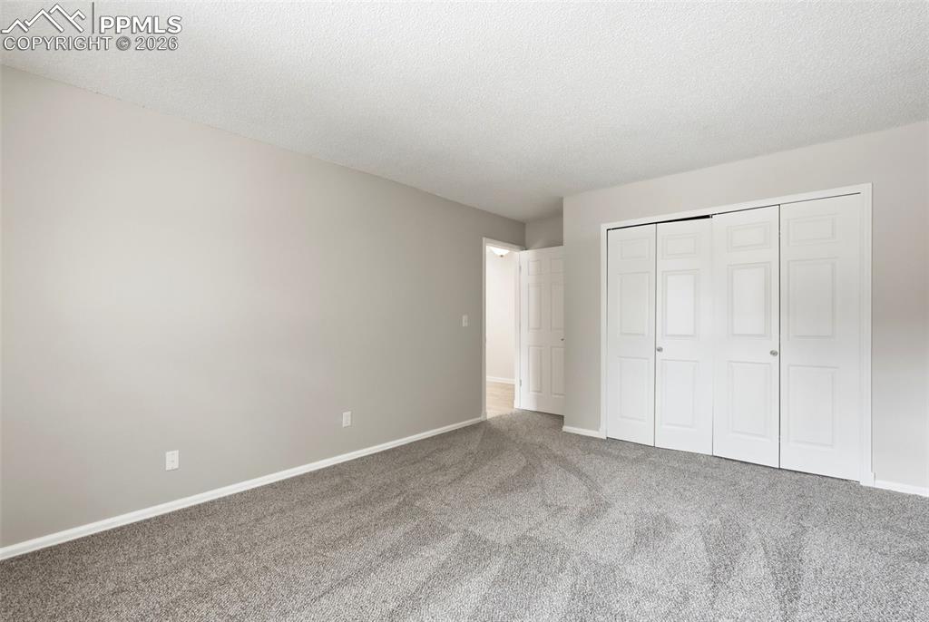 Image 25 of 44: This interior space features light grey walls and a grey patterned carpet